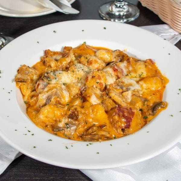 Bella Pasta's gnocchi in a creamy orange sauce with mushrooms, bacon, and melted cheese.